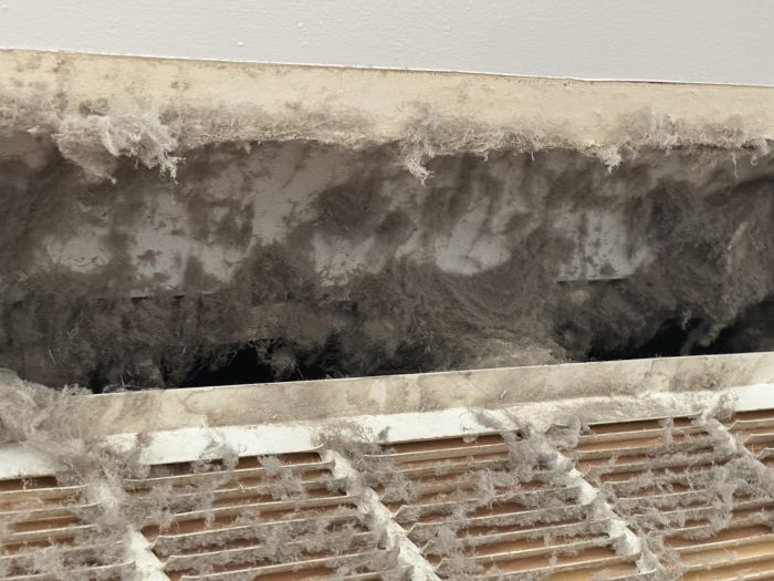 inside look at a air duct vent that is super fluffy and dirty with dust